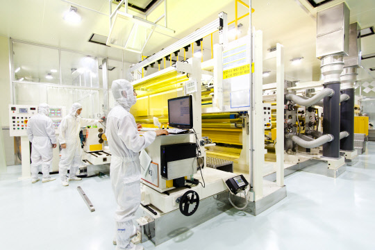 PI첨단소재 공장에서 직원들이 폴리이미드 필름 소재 생산공정을 관리하고 있다. PI첨단소재 제공